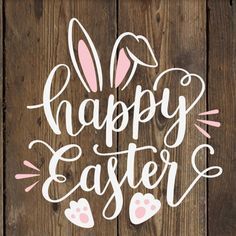 the words happy easter written in white on a wooden background with bunny ears and paws