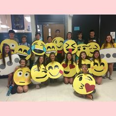 a group of people holding up smiley faces