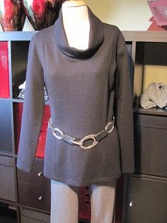 a mannequin is wearing a gray coat and pants with chains on the belt