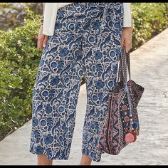 a woman carrying a handbag while walking down a sidewalk