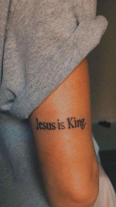 a person with a tattoo that says jesus is king