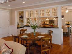 a dining room table and chairs in front of an open kitchen