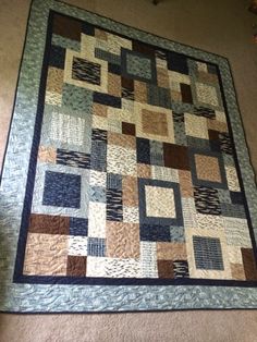 a blue and brown quilt hanging on the wall