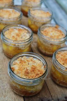 several jars filled with food sitting on top of a wooden table next to peaches