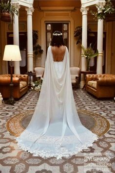 the back of a woman's wedding dress is shown in an ornately decorated room