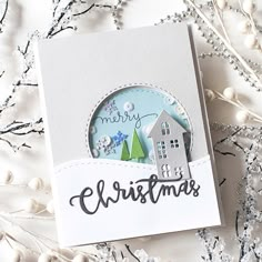 a close up of a christmas card with snowflakes and trees in the background