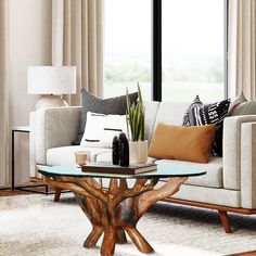 a living room filled with furniture and a glass top table in front of a window