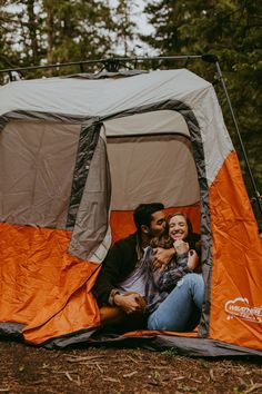 a man and woman are sitting in a tent