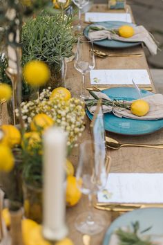 the table is set with lemons and greenery for an elegant dinner or party