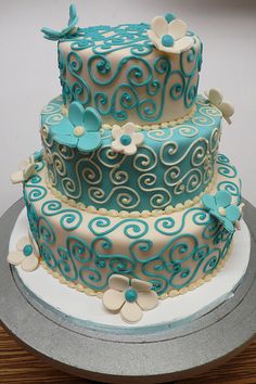 a three tiered cake with blue and white decorations