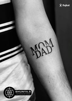 a man with a tattoo on his arm that says mom and the word dad written in black ink