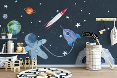 a child's room with space themed wallpaper and toys on the floor in front of it