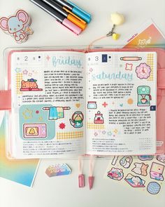 an open planner book with stickers and pens on it, next to other stationery items