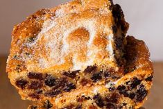 two pieces of fruitcake stacked on top of each other with powdered sugar and raisins