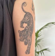 a tattoo on the arm of a woman with a leopard in it's body