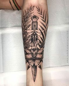 a black and white tattoo on the leg of a person with a knife in it