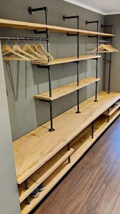 an empty walk in closet with wooden shelves and metal rails on the wall, next to a hardwood floor