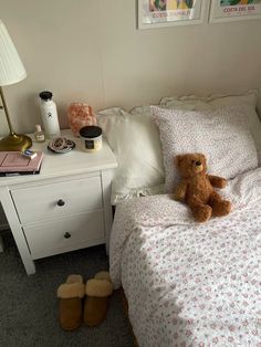 a teddy bear sitting on top of a bed in a bedroom next to a night stand