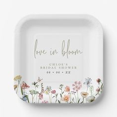 a white plate with flowers on it and the words love in bloom printed on it