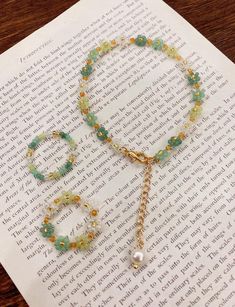 a book with a necklace and bracelet on top of it next to an open book