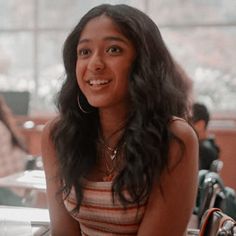 a young woman sitting at a table smiling