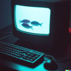 an old computer with two fish on the screen and a keyboard in front of it