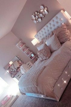 a bedroom with a large bed and lots of lights on the headboard is shown