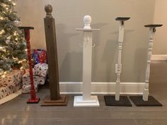 three wooden poles are standing in front of a christmas tree with presents on the floor