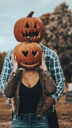 a woman holding two pumpkins on top of her head