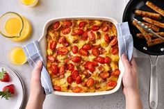 a person is holding a napkin over a casserole dish with strawberries on it