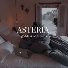 a laptop computer sitting on top of a bed covered in blankets and pillows with the words asteria above it