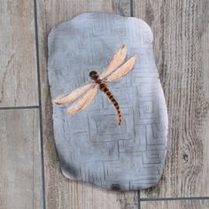 a dragonfly painted on the side of a stone