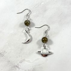 Moon and Saturn mismatched earrings. Made with labradorite gemstone and a moon/Saturn charm. Made with fishhook style earrings. I offer both a standard and hypoallergenic option for the hooks. The standard is stainless steel and the hypoallergenic is 925 sterling silver plated. Ships in a jewelry box so it's ready to be give as a gift. All materials are lead and nickel free. Charm is made with zinc alloy.  Earrings will be disinfected before shipment but should also be cleaned every time before wearing. Adjustable Moon Charm Earrings, Saturn Earrings Diy, Saturn Accessories, Moon And Saturn Earrings, Moon And Saturn, Saturn Jewelry, Saturn Charm, Saturn Earrings, Beads Craft Jewelry