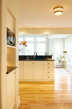 an open kitchen with white cabinets and wood floors