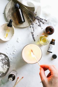 a person holding a spoon in front of an assortment of essentials on a table