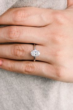 a woman's hand with a diamond ring on it