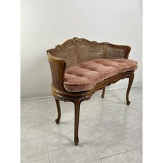 a wooden bench sitting on top of a tile floor next to a white tiled wall