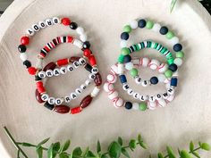 two bracelets sitting on top of a white plate next to green plants and leaves