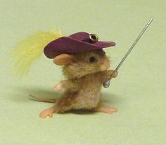 a toy mouse with a purple hat on it's head holding a small stick