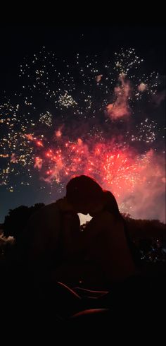 two people are kissing in front of fireworks