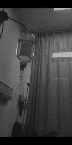 a black and white photo of a hospital room with an iv monitor on the wall