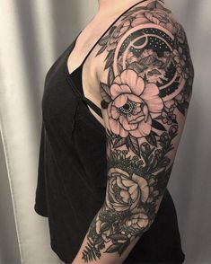 a woman's half sleeve with flowers and moon tattoo on her left upper arm