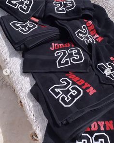 black sweatpants with red and white numbers are laid out on the ground next to each other