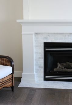 a living room with a fire place and wicker chair