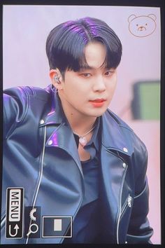 a young man with black hair and piercings wearing a blue leather jacket is looking at the camera