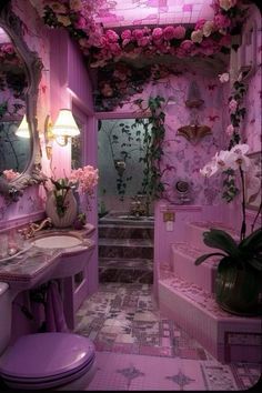 a bathroom decorated in pink and white with flowers on the ceiling, toilet, sink and mirror