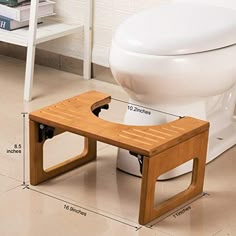 a white toilet sitting next to a wooden stool