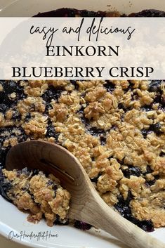 blueberry crisp in a casserole dish with a wooden spoon on the side