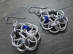 "These chainmaille earrings were woven in the Helm weave using lightweight silver aluminum and anodized aluminum rings in black, matte grey, matte white, and purple. They have niobium French hook earwires and are quite light due to the materials I used to create them, so they are easy on the ears. These represent the colors of the Asexual Pride flag. Length: About 2\" Colors: Silver, Black, Matte Grey, Matte White, Purple Materials: Anodized Aluminum Rings, Bright Aluminum Rings Earwires: Niobiu Black Stainless Steel Chainmail Jewelry, Chainmaille Earrings, Goth Prom, Pride Jewelry, Dangle Plugs, Gift Crafts, Ace Pride, Pride Jewellery, Asexual Pride