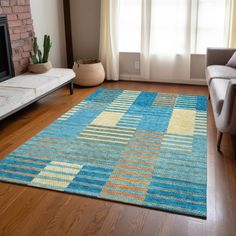 a living room with a couch, chair and rug on the hardwood floor next to a fire place